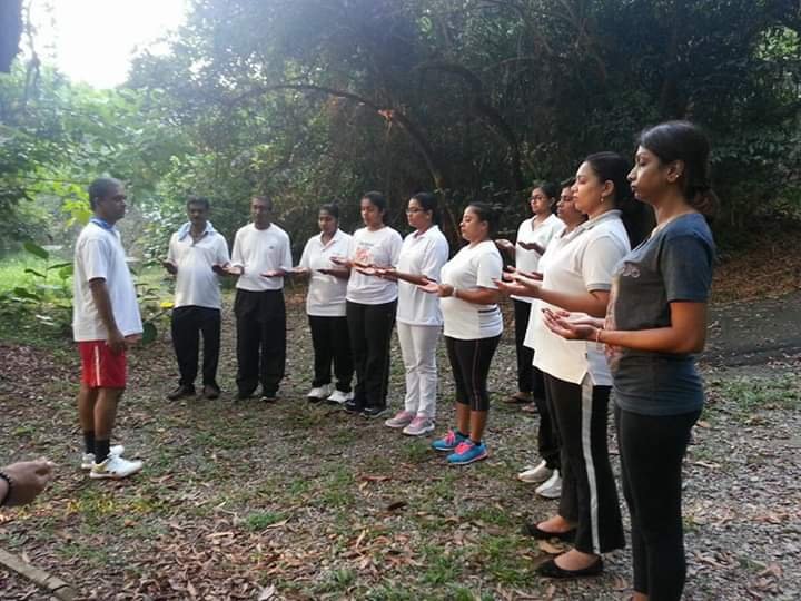 Enhancement program for adults 2 Mindfulness & Well-being : Outdoor group activity with people standing in a line tapping pure energy