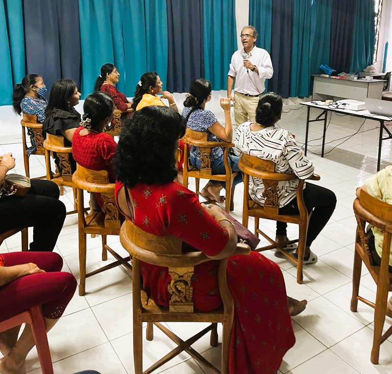 Asohan at a workshop participants seated at tables, interactive session